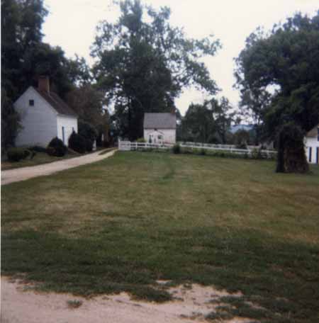 A color photograph of several white buildings and green grass.