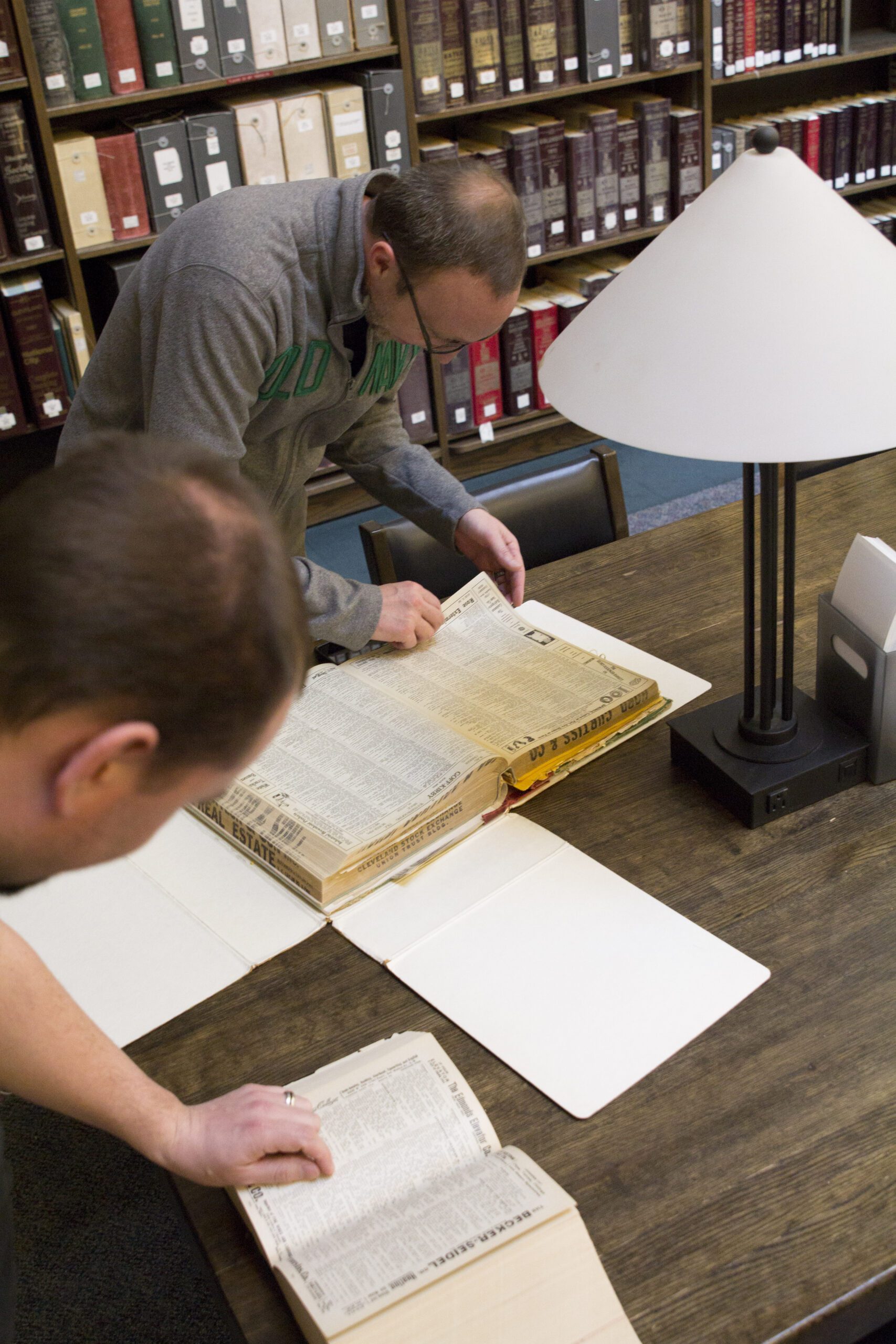 An image of 2 people studying genealogy in the library