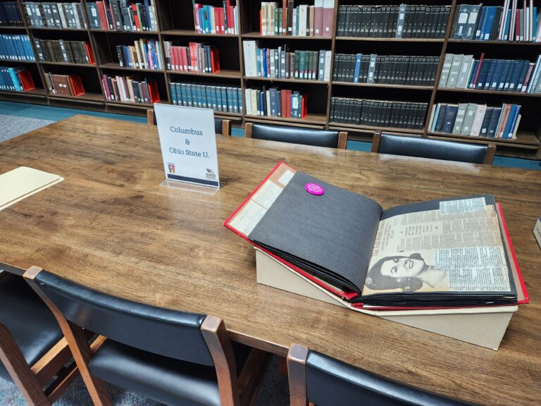 A photo of a wooden table with a manuscript album from the GOHI Collection laid out on it.