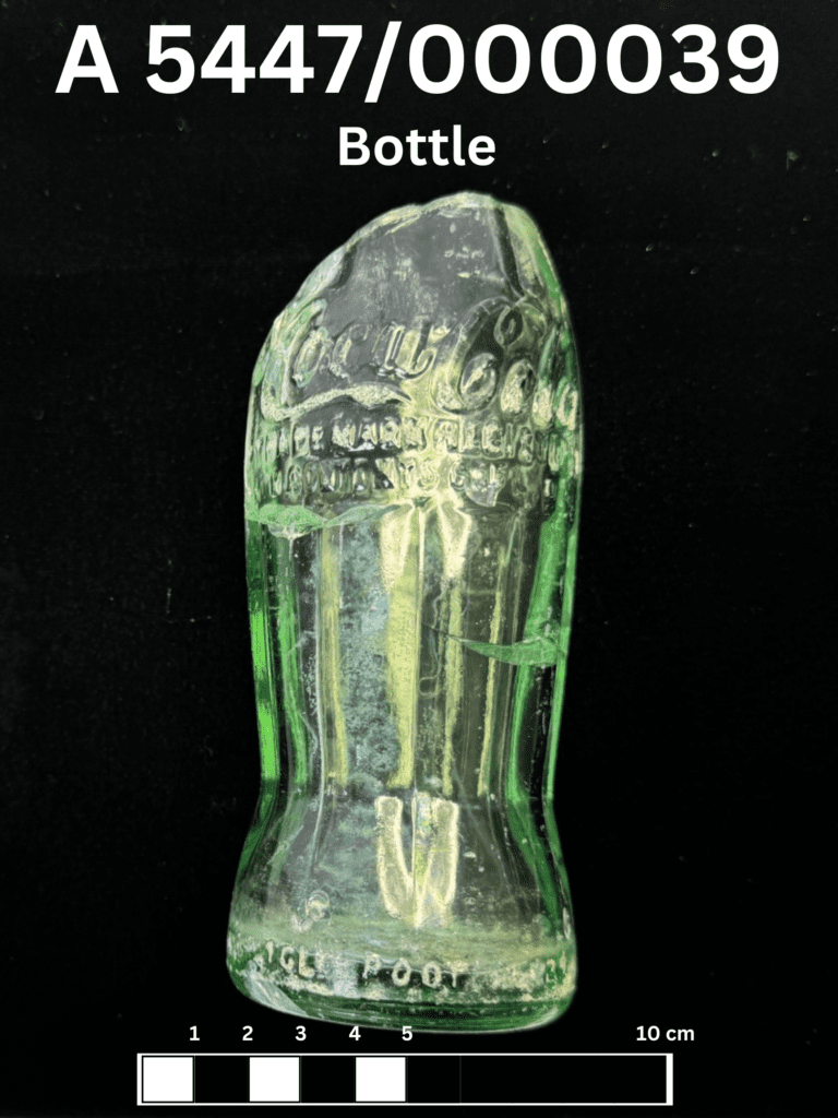 A green coca cola bottle fragment. The neck and rim are missing but most of the glass is intact otherwise.